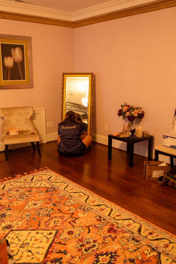 Bridesmaid sitting in front of a mirror getting ready